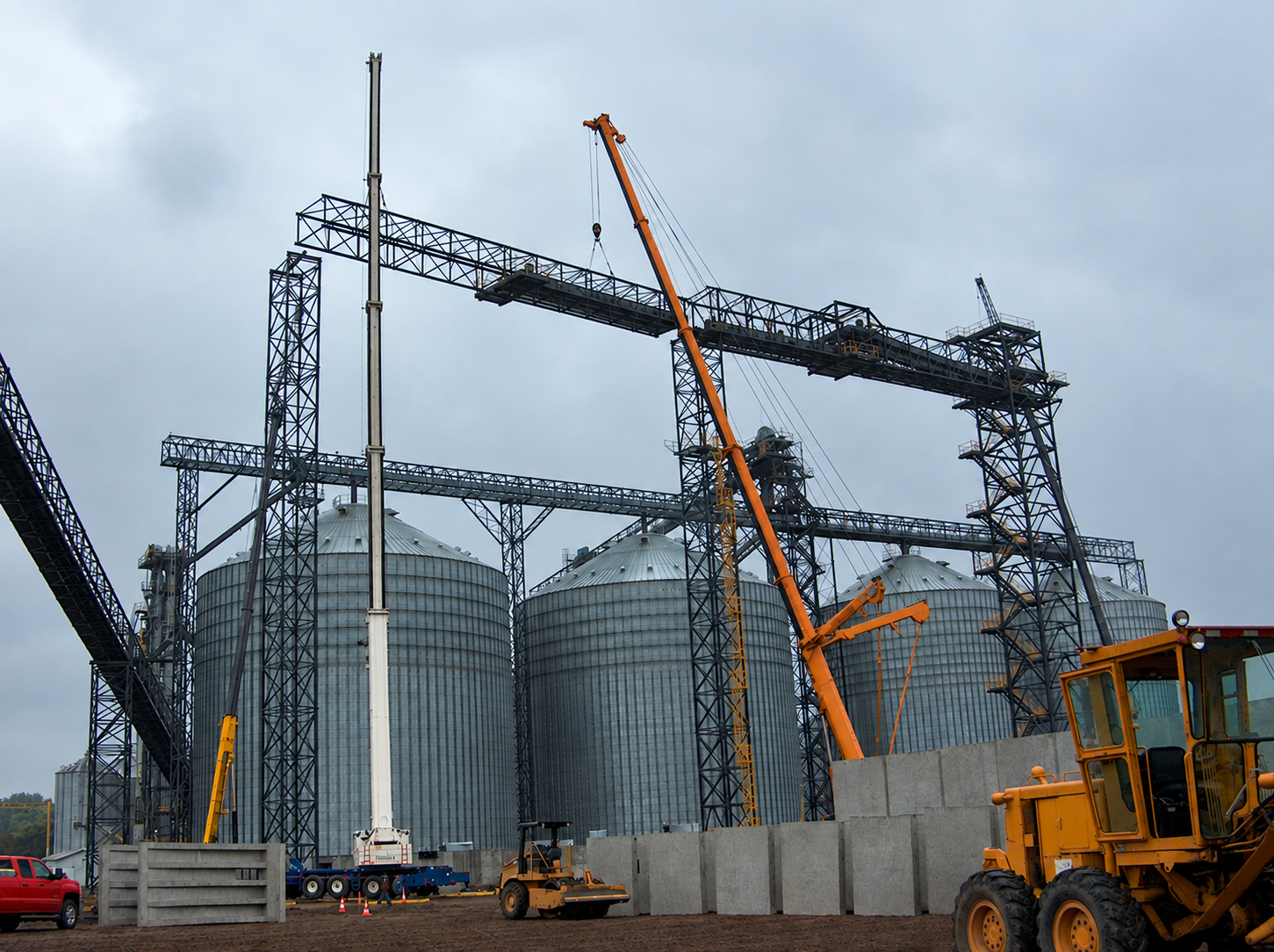 Grain Silos and Cranes Under Gray Skies